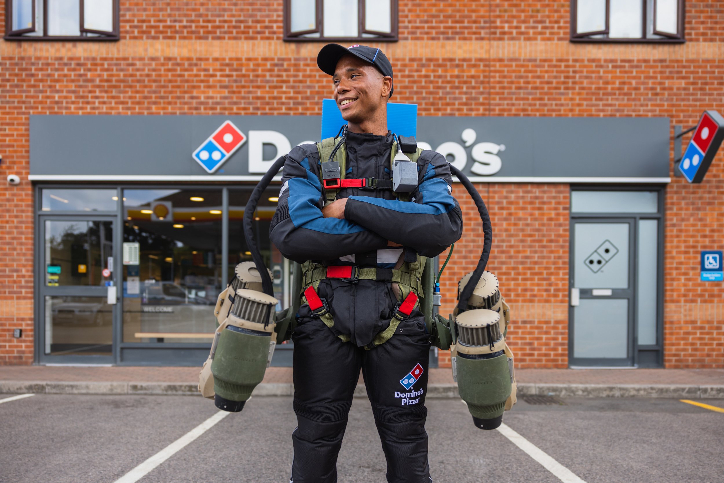 An image of a dominos delivery driver with a jetpack on his back.