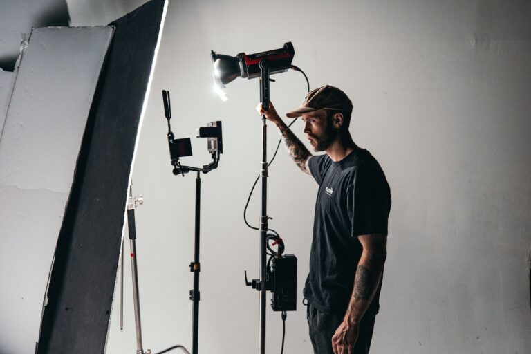 A key grip standing on set adjusting a piece of equipment.