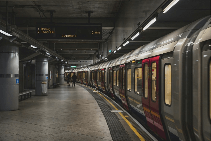 London tube passing by two passengers as they wait to get on the train.