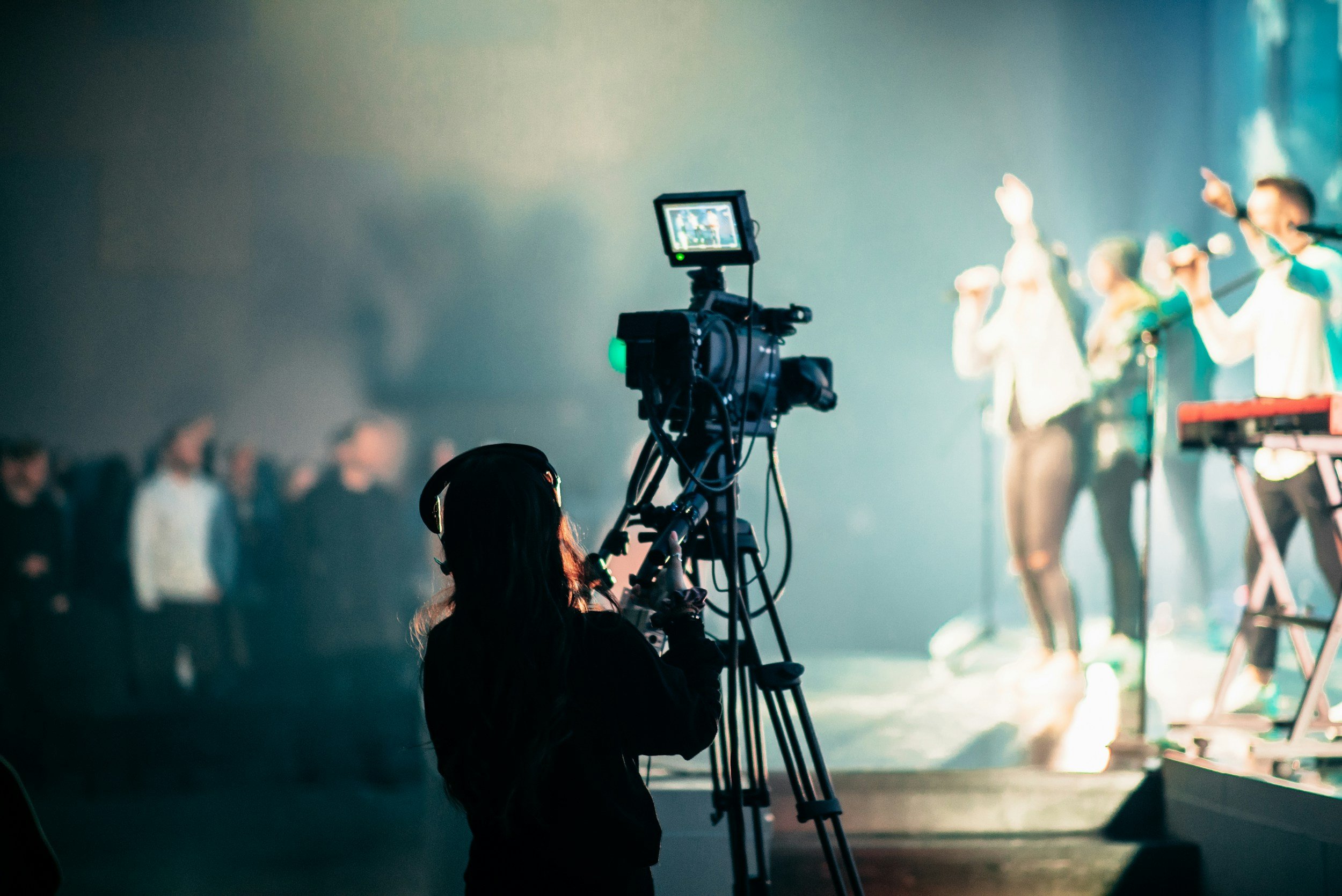 A photo of a runner standing next to a camera watching a concert.