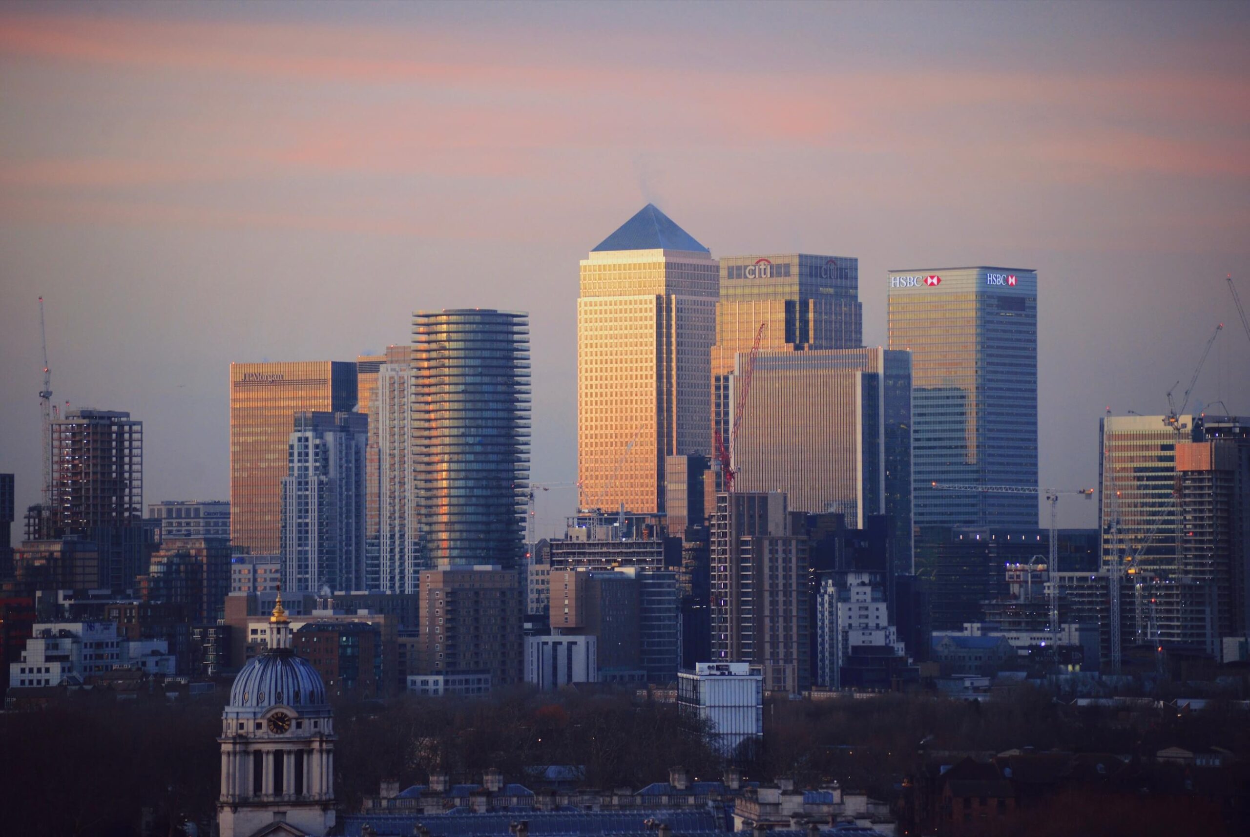 An image of Canary Wharf, London, at sunrise with the One Canada Square Building in the middle.