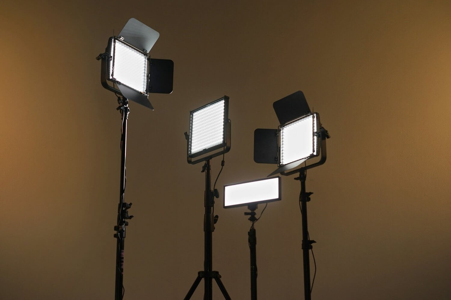 4 film lights in front of a beige back drop.