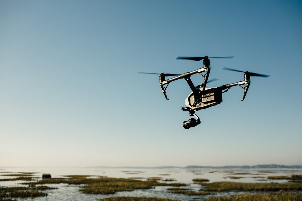 An image of a DJI Inspire flying in the sky with a blue background.