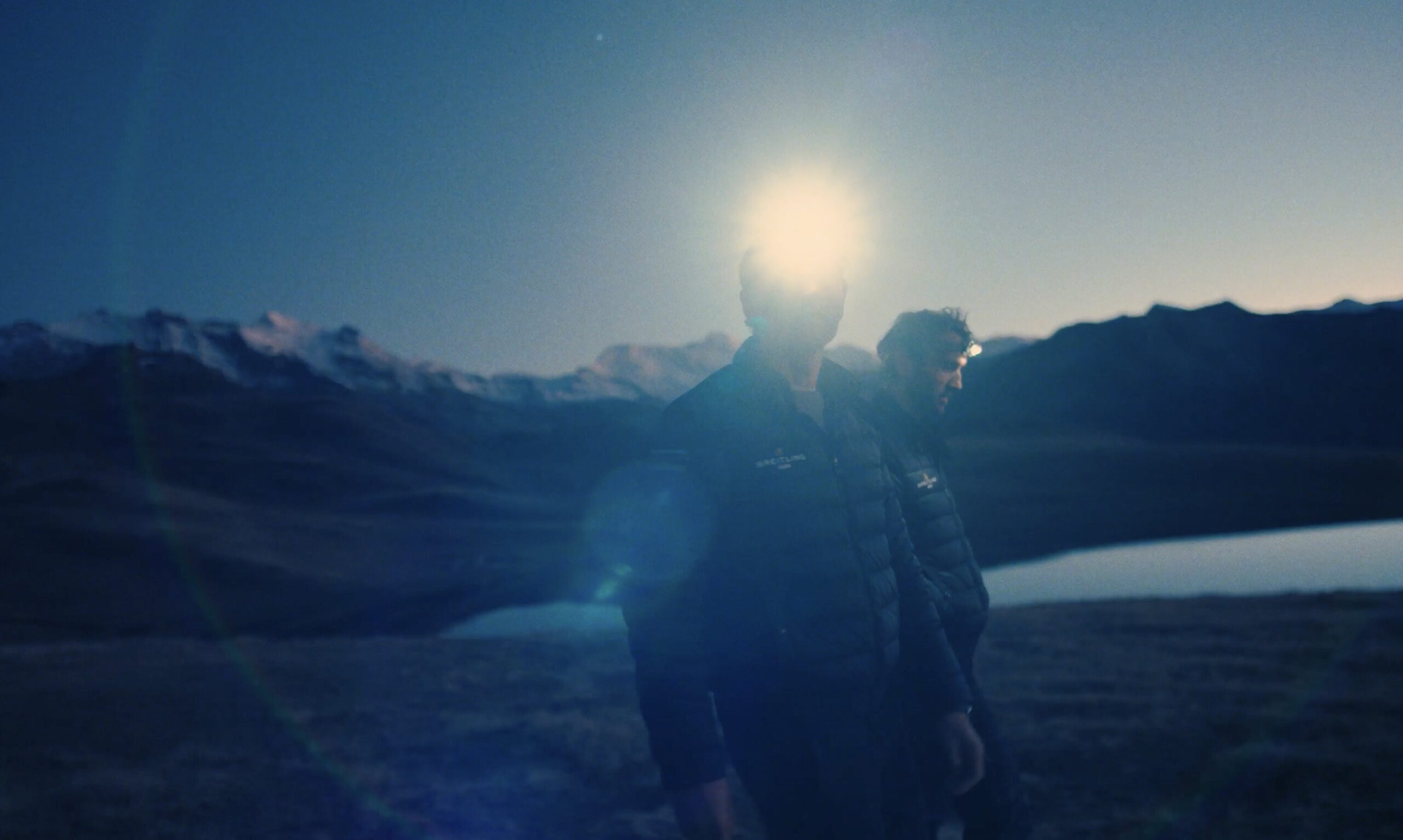 Hugo and Ross Turner at night in the French Alps with head torches on.