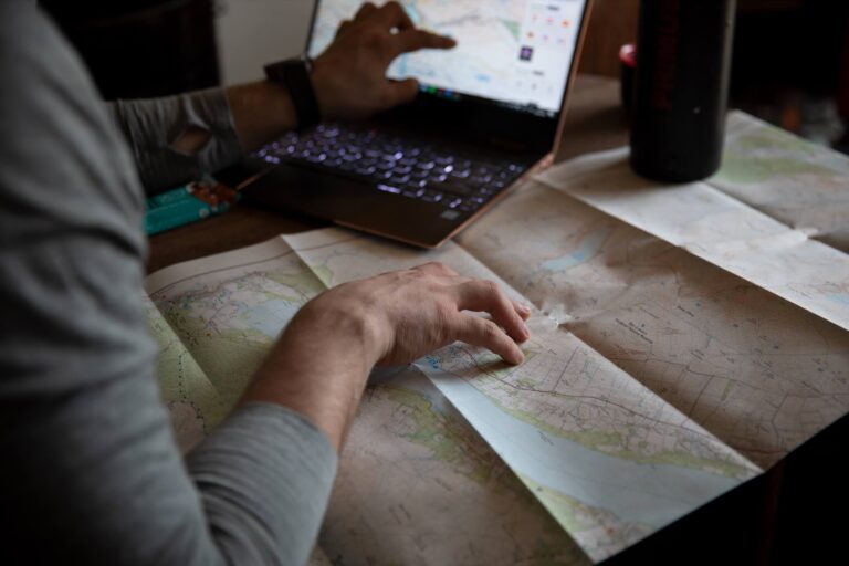 An image of Charlie Smith, Adventurer and Explorer, looking over maps and a laptop.