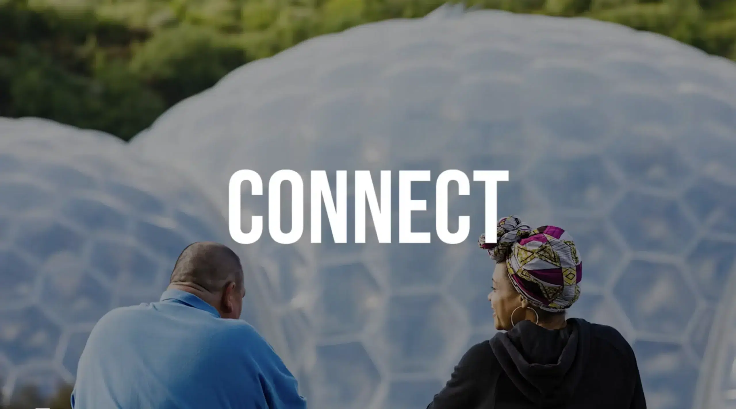 An image of the eden project biomes with the words "imagine" on screen. 