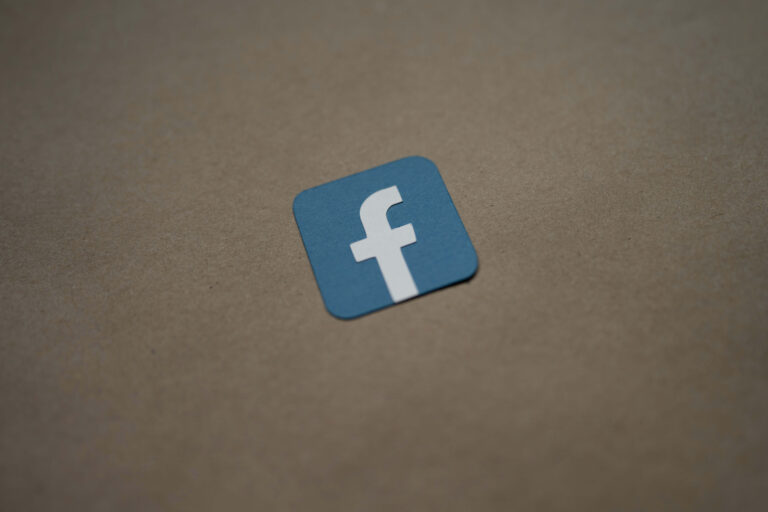 A blue and white facebok logo on a brown paper background.