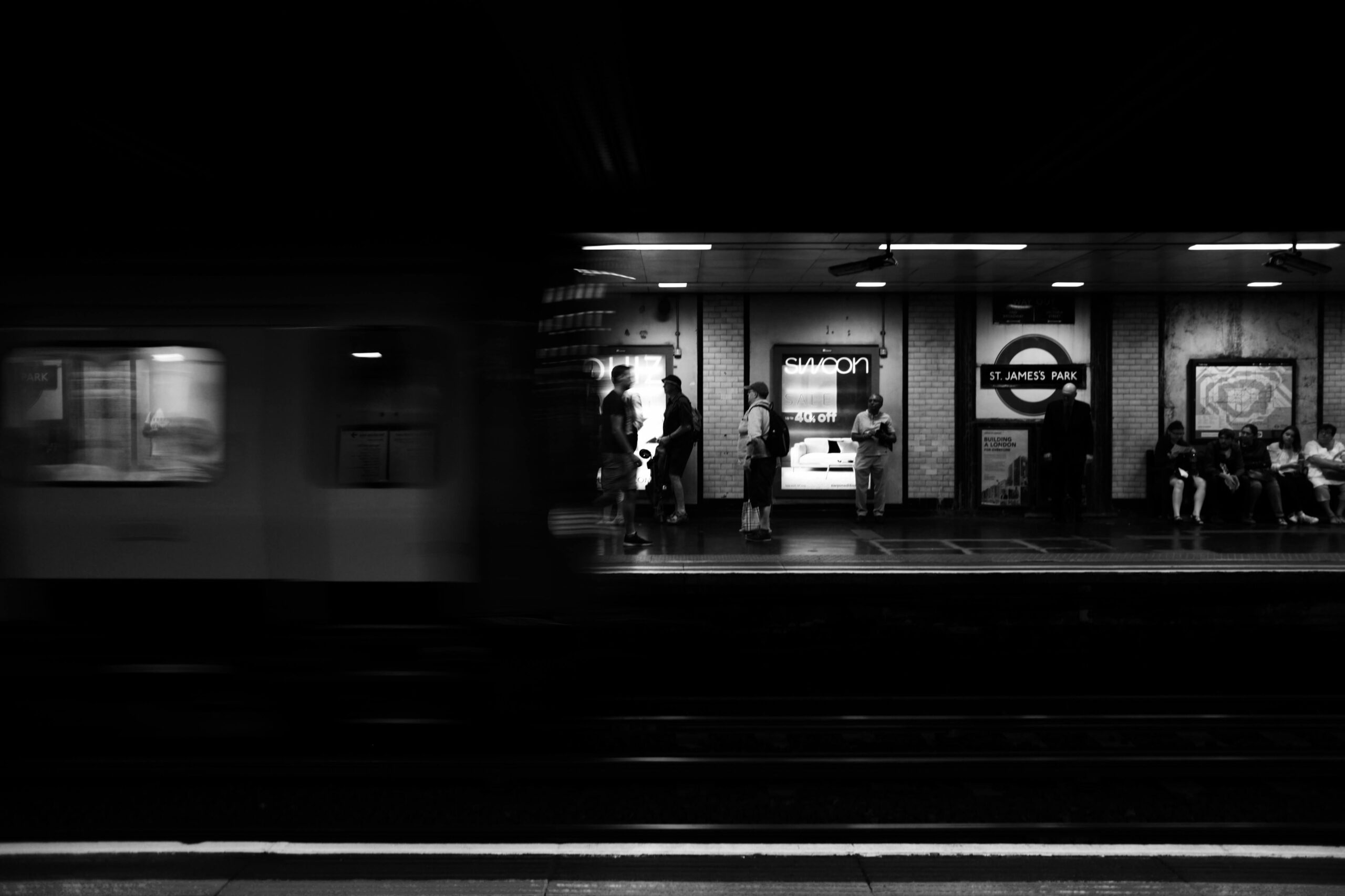 A black and white image of a London underground tube platform