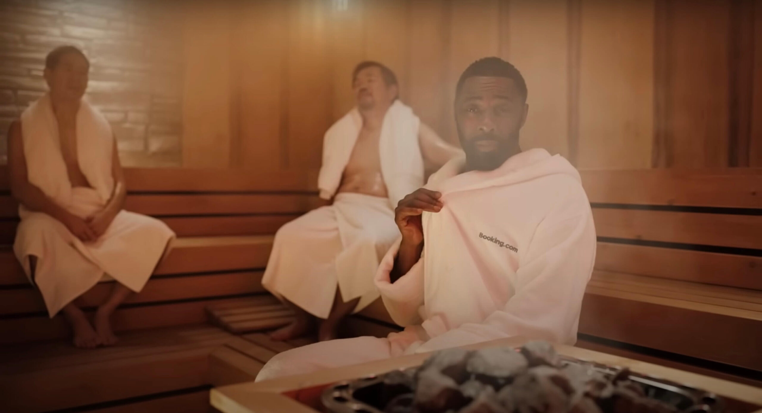 An image of Idris Elber in a Sauna with e booking.com dressing gown on.