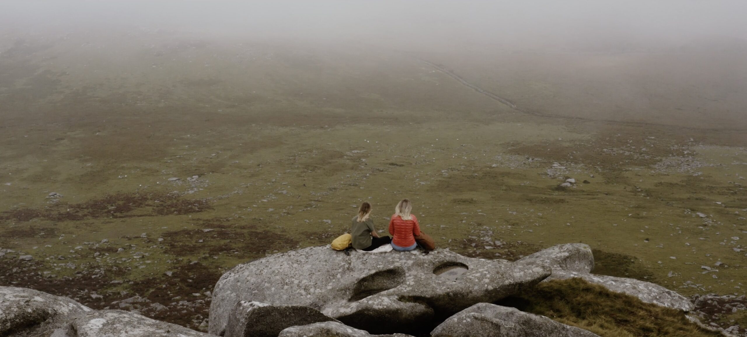 An image of Sophie Hellyer and friend sitting on a Cornish Granit tour wearing Kathmandu Clothing.