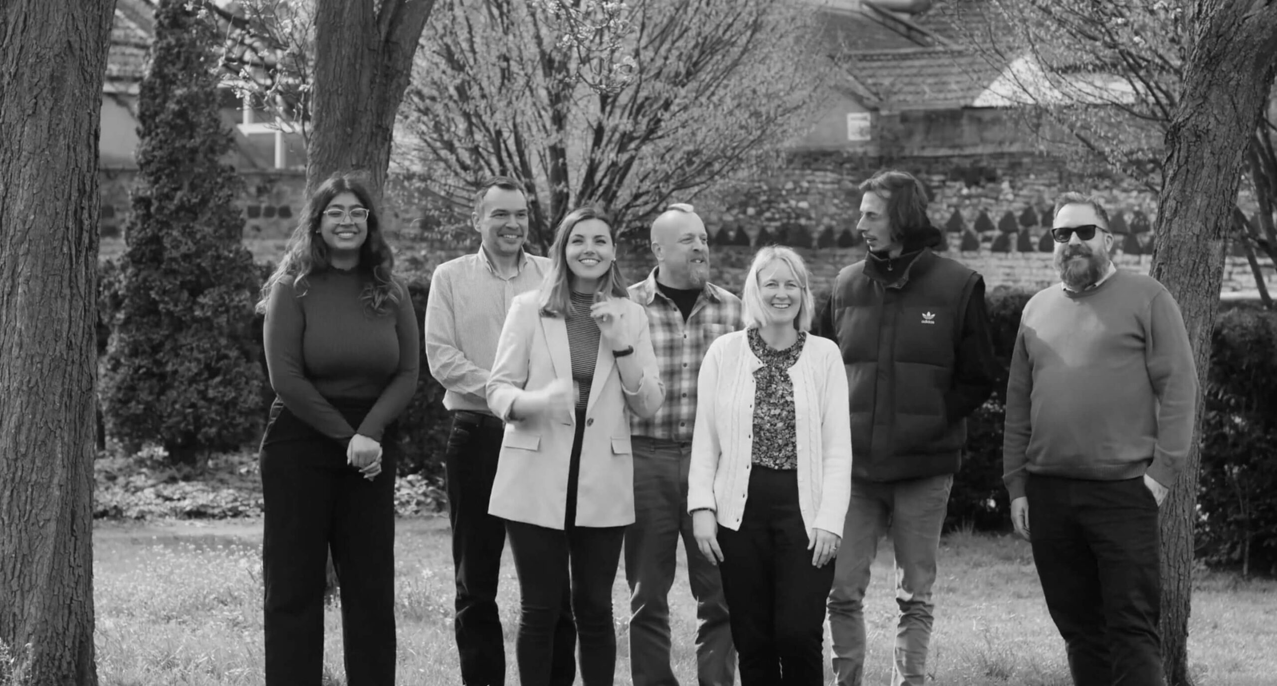 The staff from The Great Western Credit Union standing together in a park.