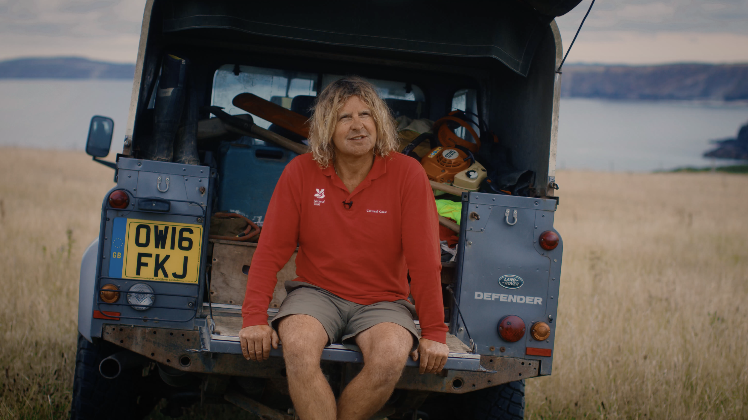 Nick Holding, a National Trust ranger, sitting in the back of a LandRover at Godrevey.