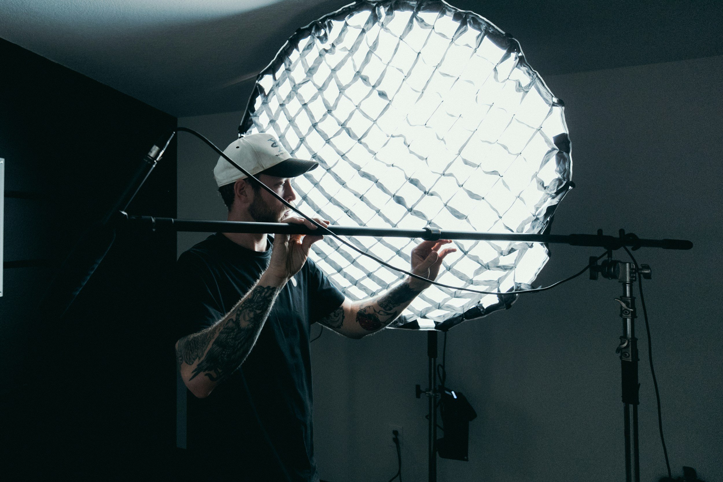 A gaffer in front of a light arranging a light stand.