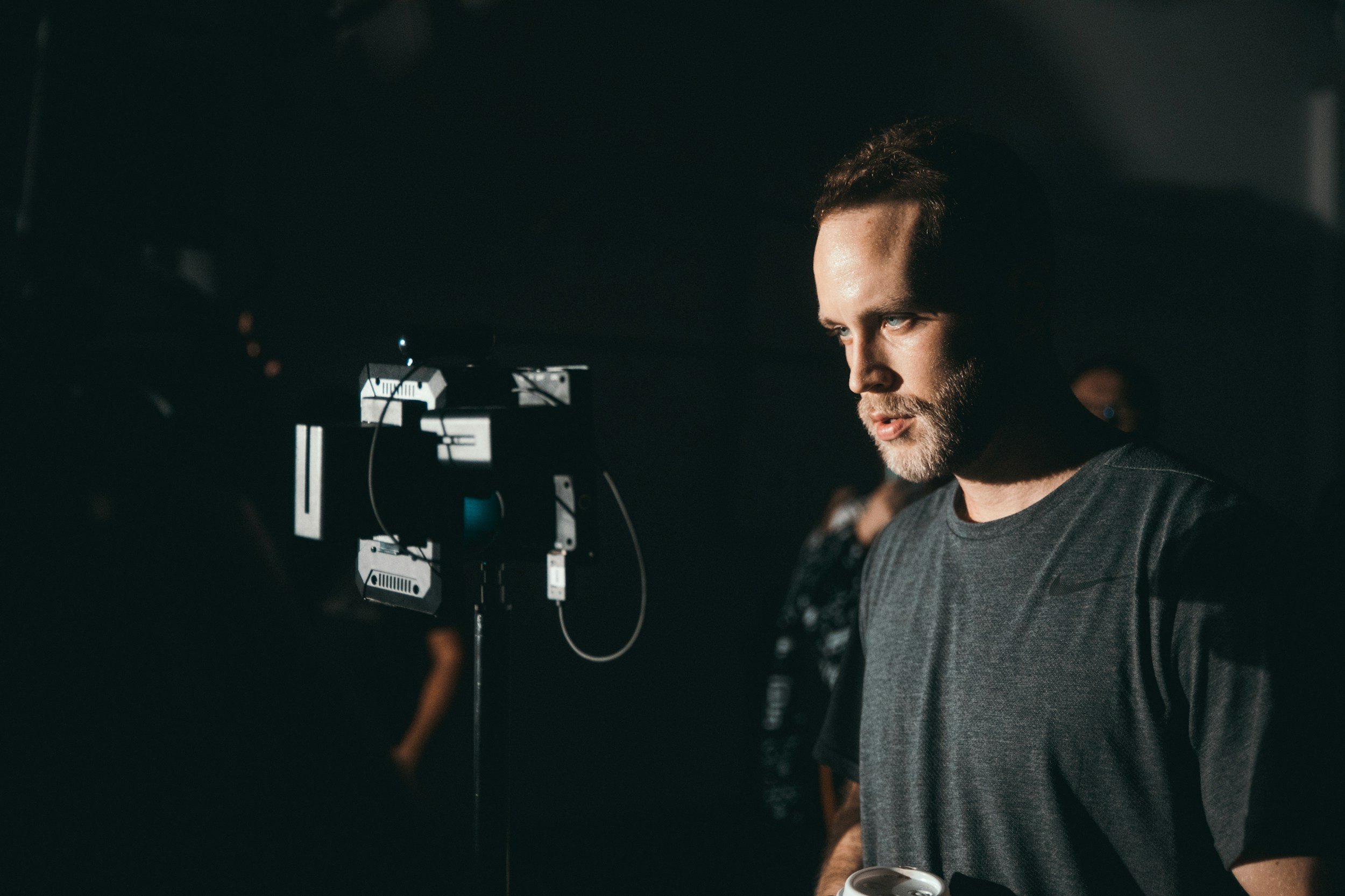 A film producer looking at a reference monitor in a studio.