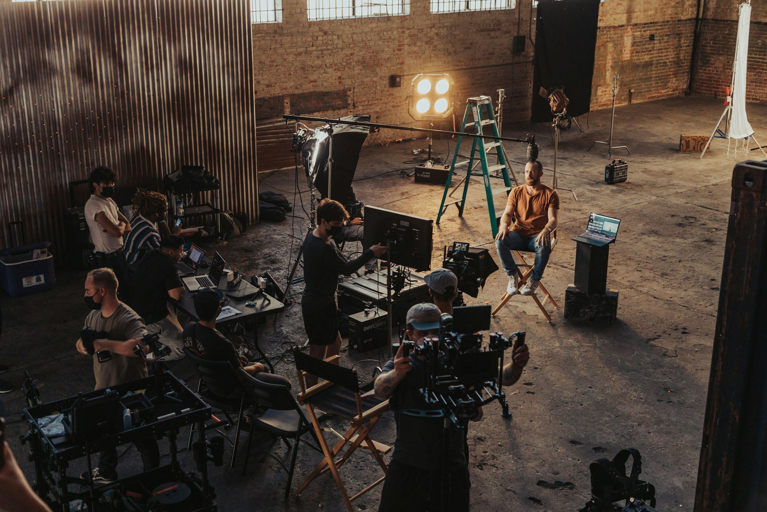 A wide angle picture of a film set with an executive producer overlooking the scene.