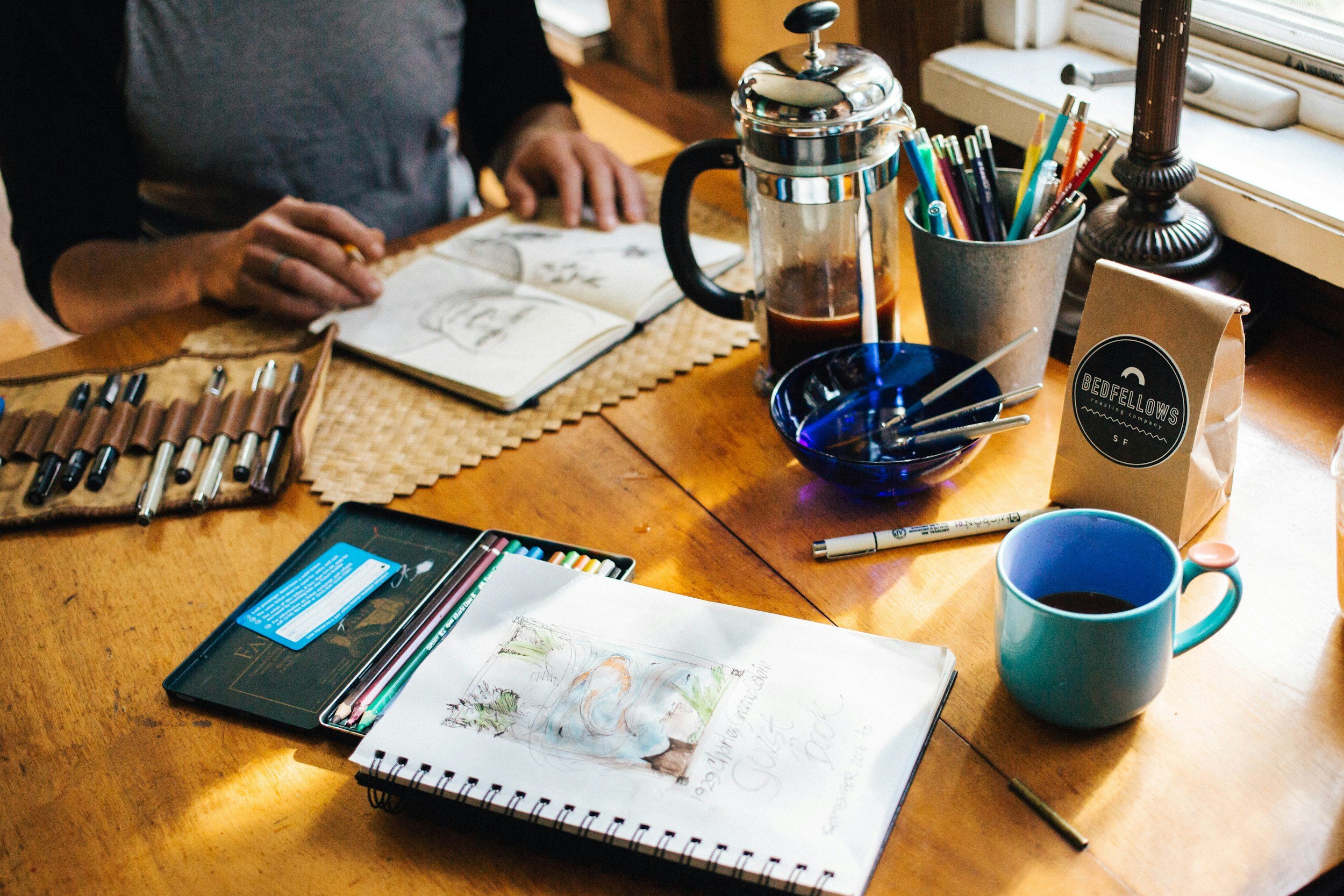 An image of an art director doing work at a coffee table.