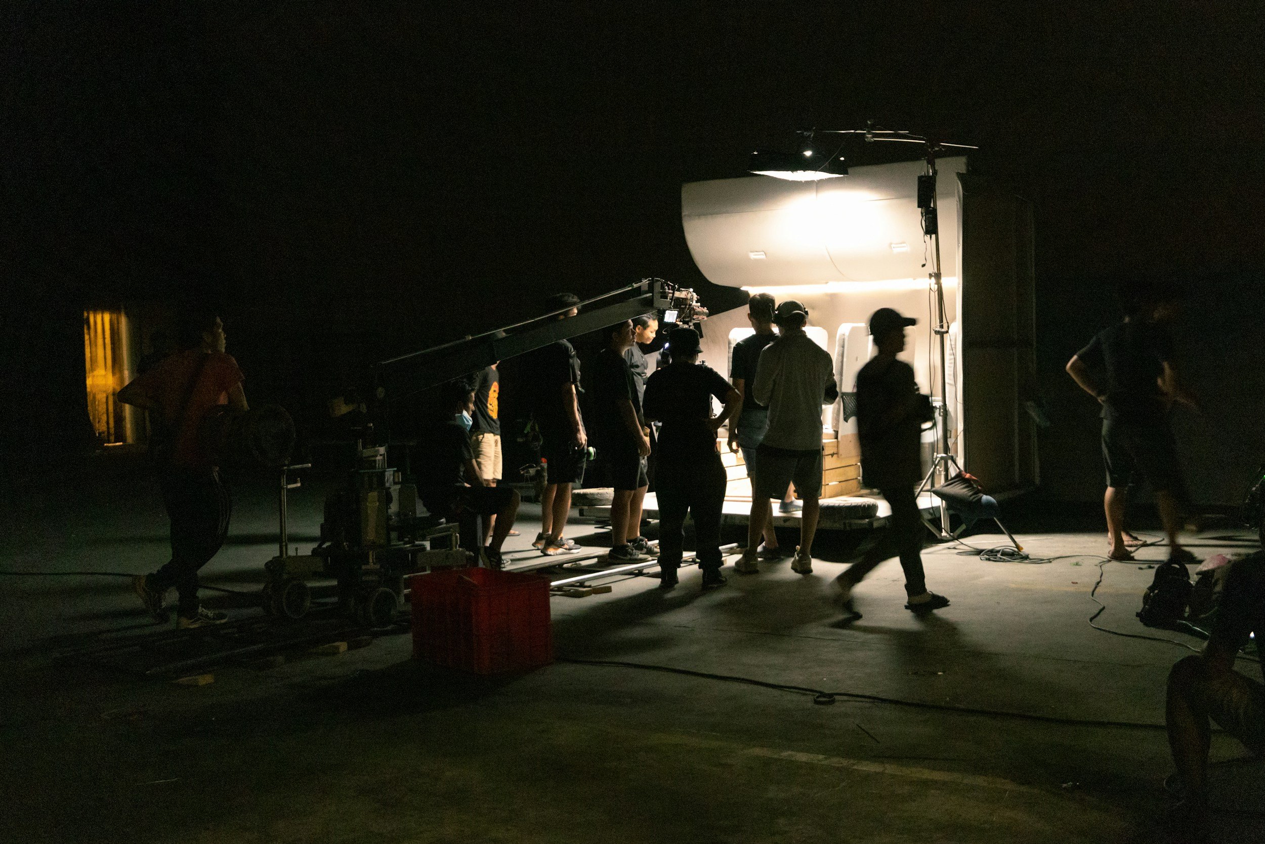 An image of a film crew at night surrounding a film set.