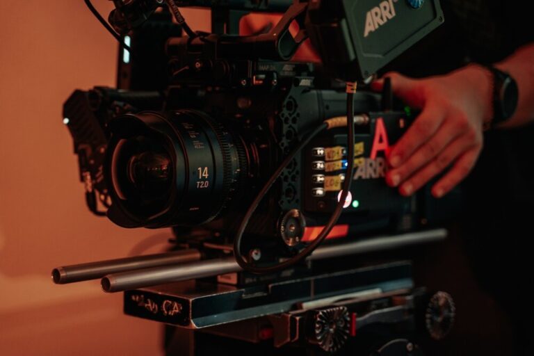 An Arri Camera with an assistant camera operator helping change a lens.