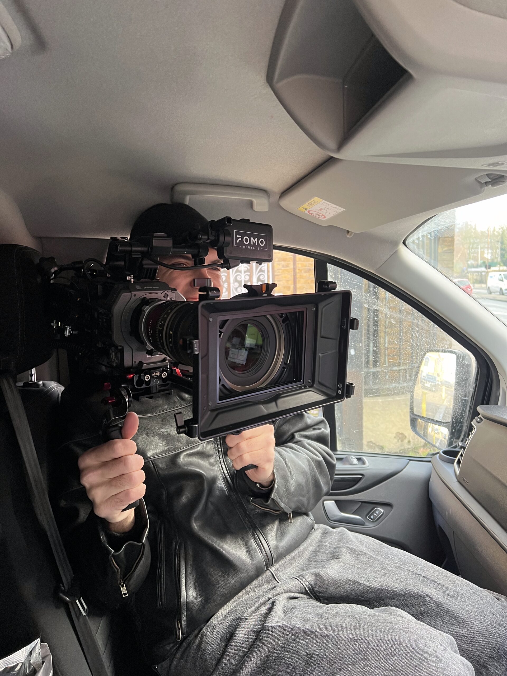 An image of a DOP holding a large Sony FX9 with a cine lens on front.